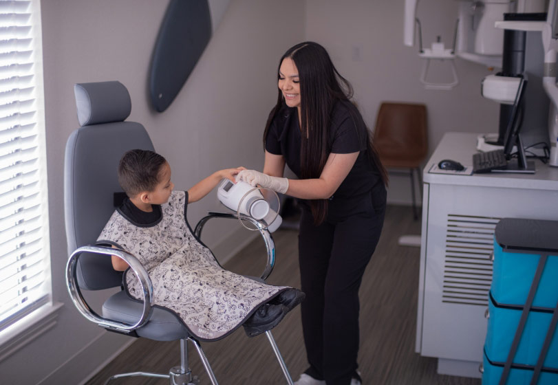 pediatric dental patient smiling before his x-rays at Sycamore Smiles in Fort Worth, TX