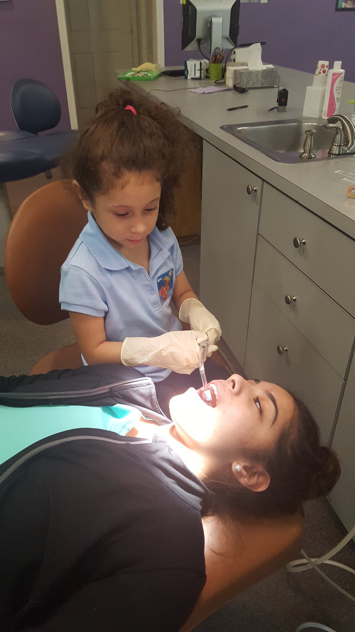A patient gives her hygienist a mouth exam to show her how easy it is so she feels more comfortable with receiving dental services at Sycamore Smiles in Fort Worth, TX.