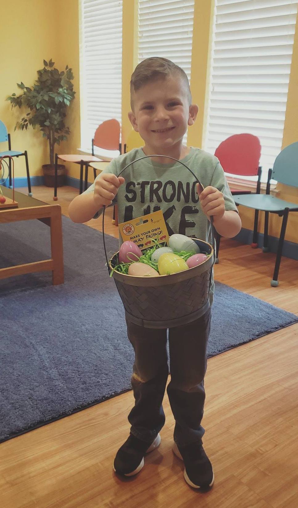 Young boy holding an easter basket given to him during a root canal appointment to help him feel better about his treatment. 