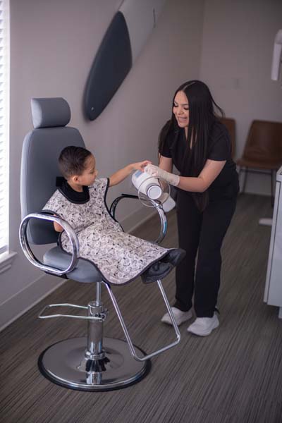 pediatric patient taking a look at the dental x-ray machine at Sycamore Smiles in Fort Worth, TX